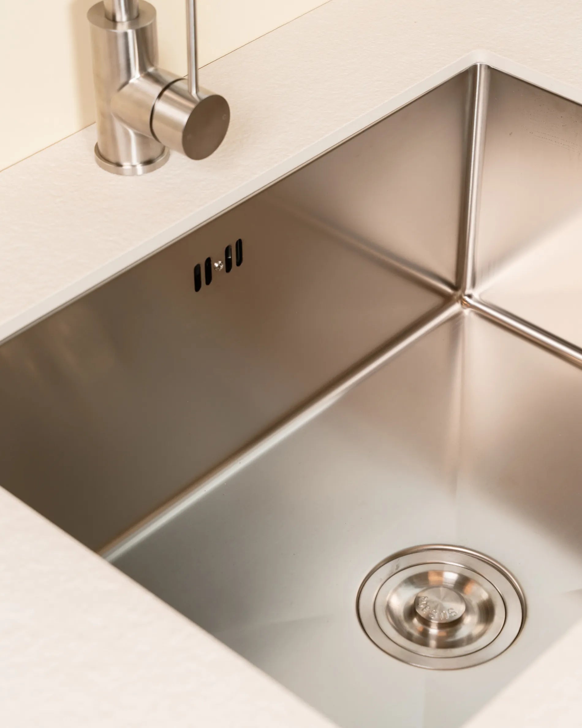 Lavello in acciaio inox del modulo Lavabo PILOTIS incassato nel piano beige crema, primo piano