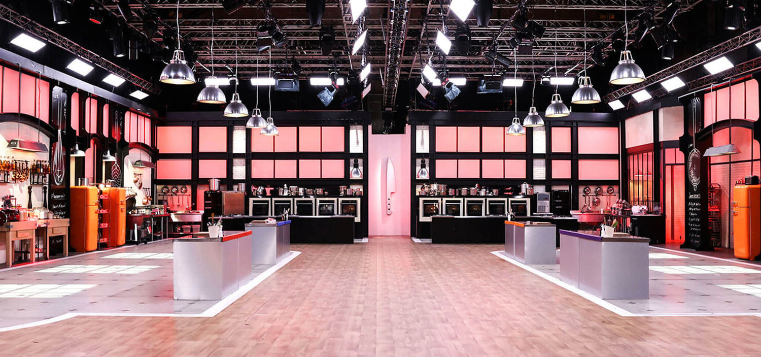 Set di registrazione del programma Top Chef, con cucine professionali, isole centrali e illuminazione da studio.