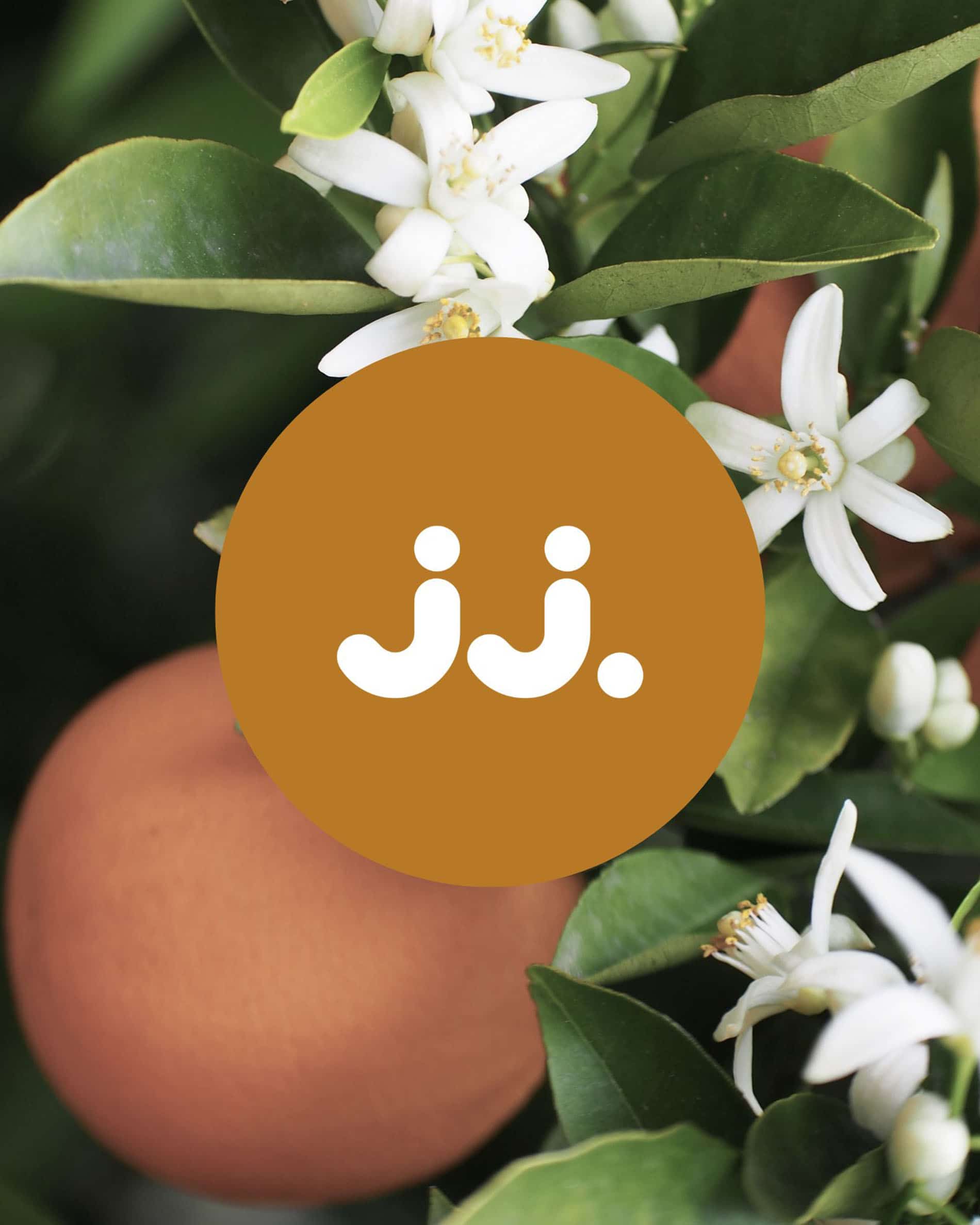 Fiori d’arancio e frutti aranciati con logo jj., per la fragranza Citronella & Fiori d’Arancio.
