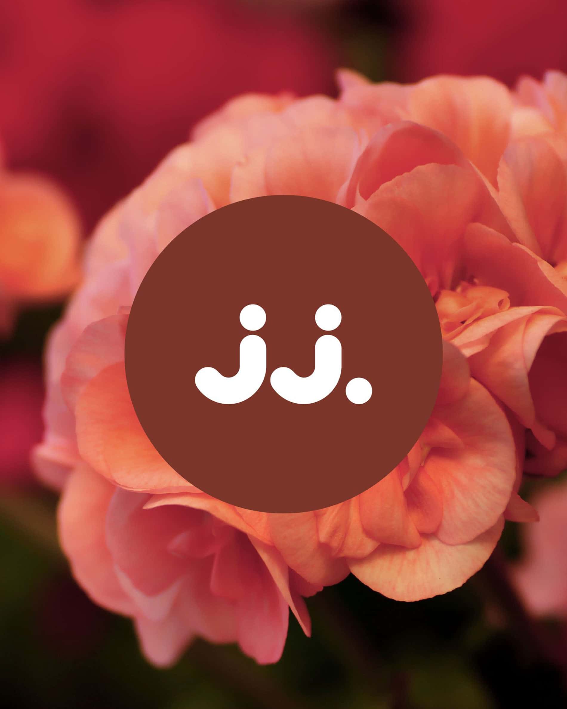 Fiori di geranio rosa con logo jj., per la fragranza Citronella & Geranio.