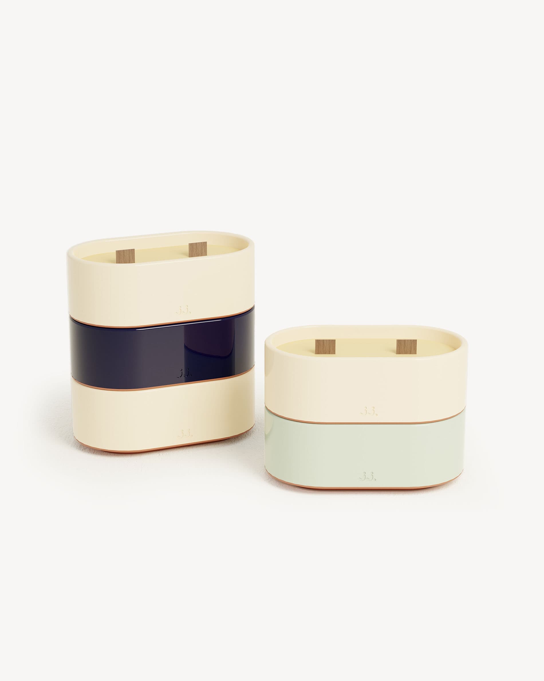 Bougie Totem S in ceramica bicolore beige avorio e blu navy, profumata alla citronella con note di limone e sale marino, presentata accanto a una versione verde acqua all’eucalipto.