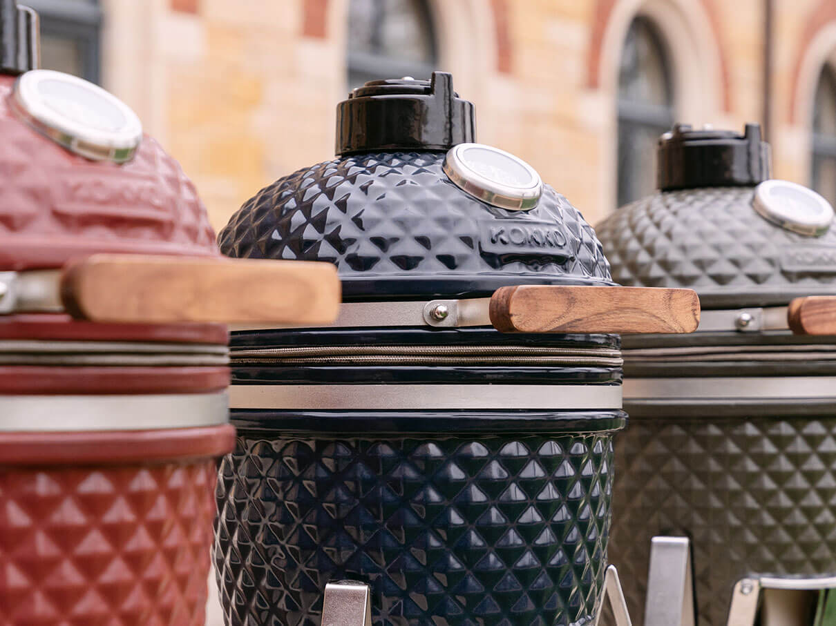 Tre kamado Kokko allineati, in ceramica rosso, blu scuro e verde oliva.