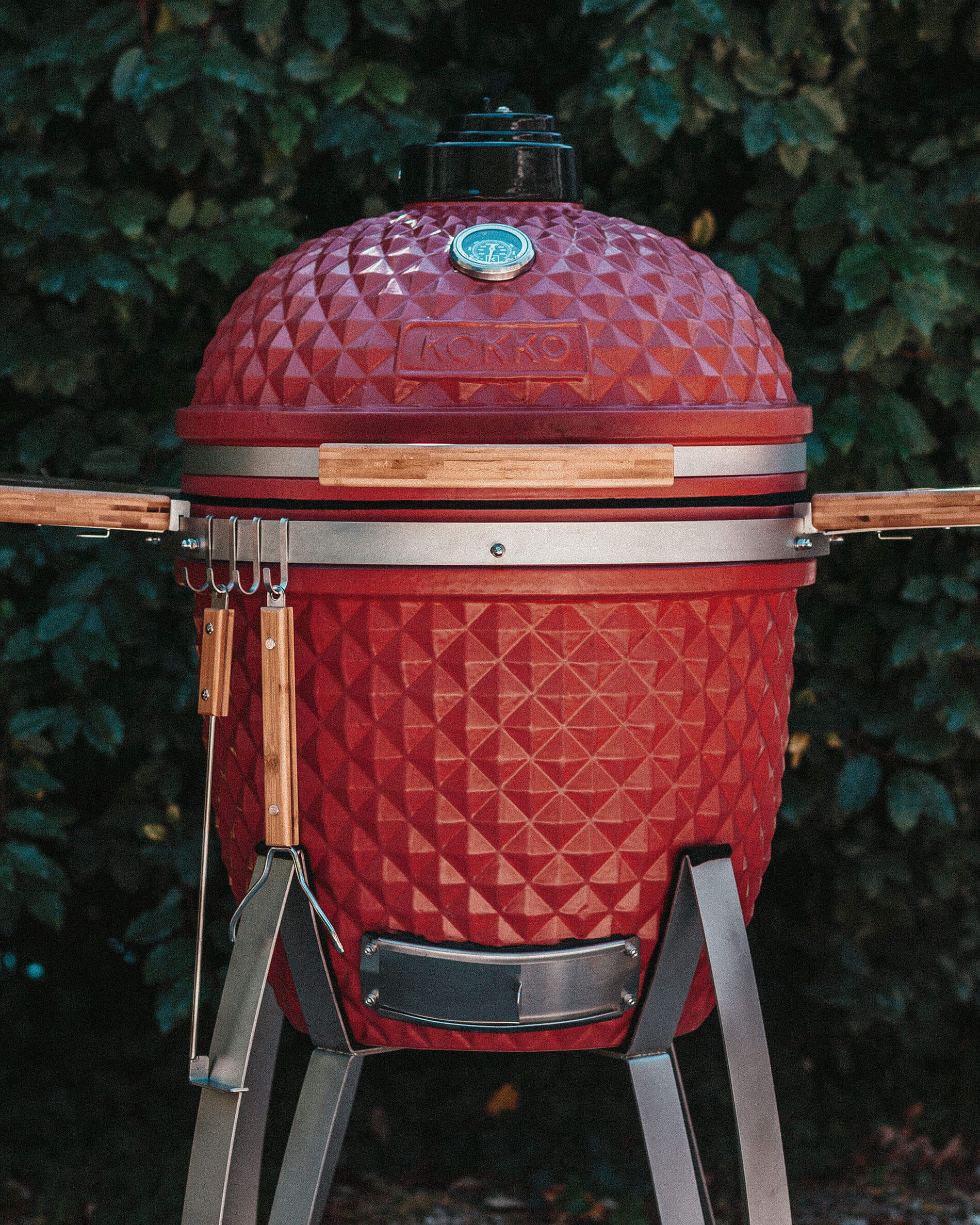 Kamado Kokko rosso dotato di ganci per accessori.