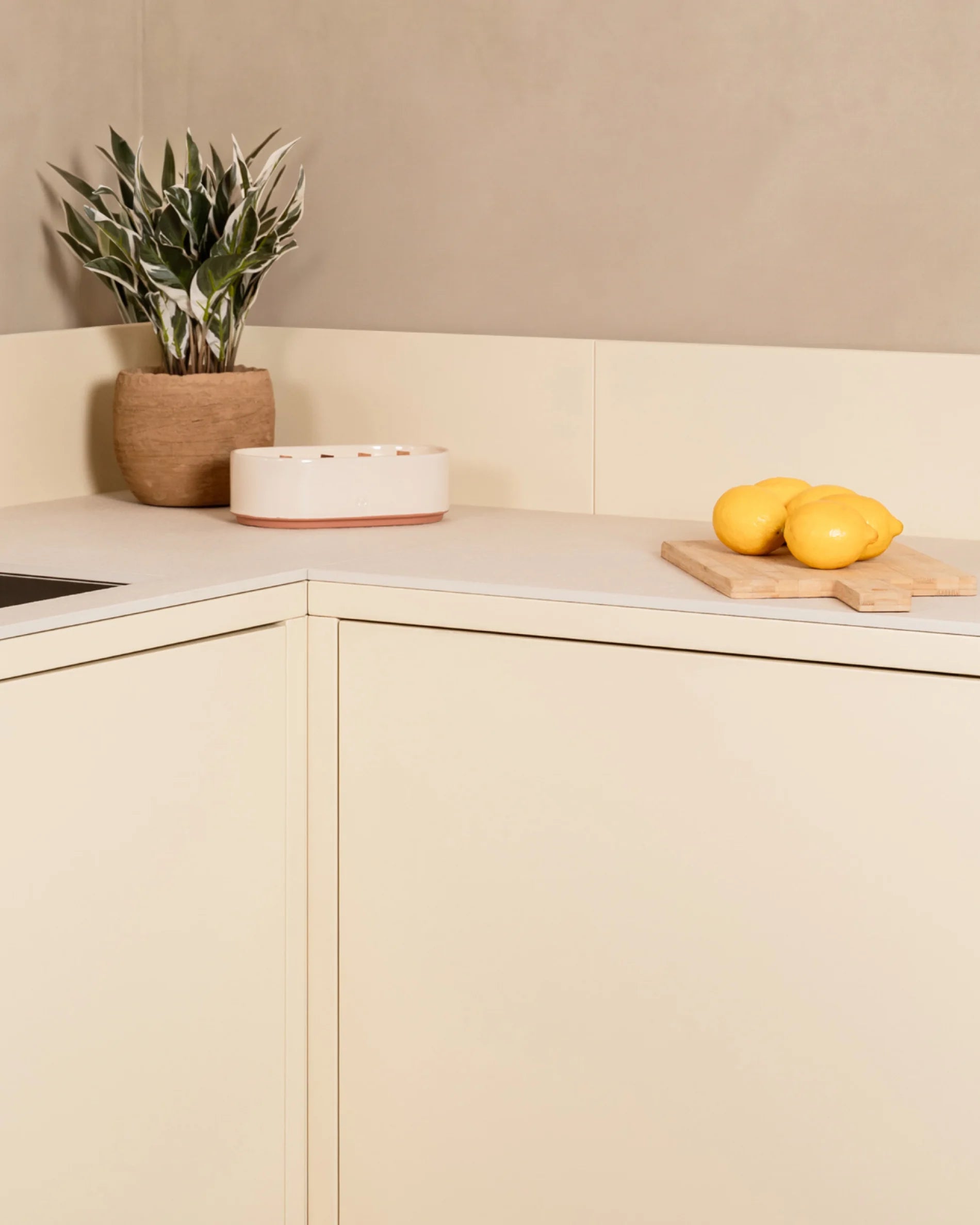 Dettaglio angolo cucina da esterno Kokko crema con piano di lavoro e decorazione vegetale