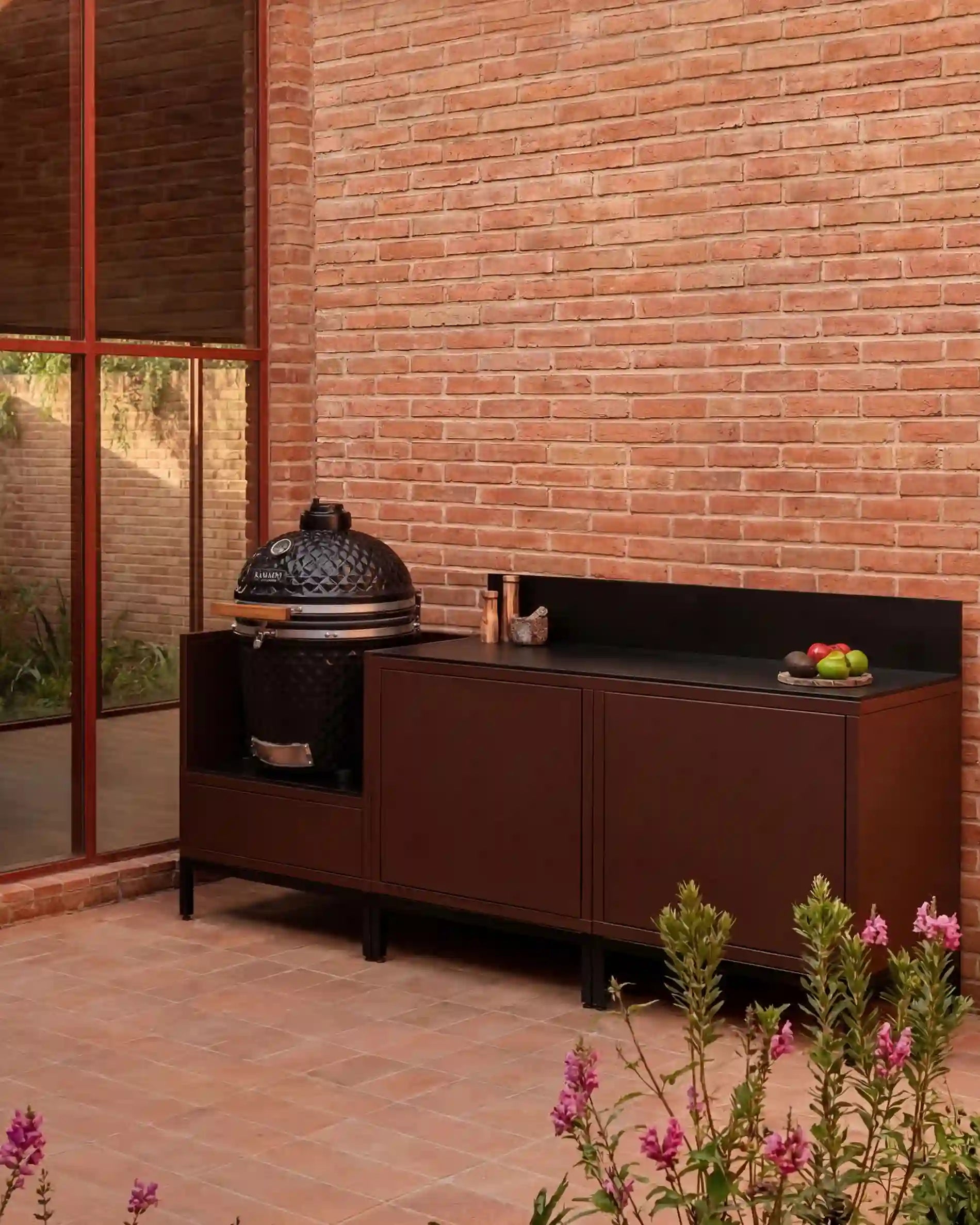 Cucina da esterno Kokko Pilotis con kamado color ruggine su terrazza