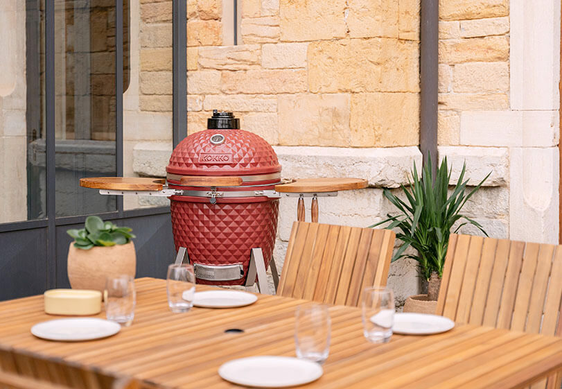 Area di cottura di un kamado Kokko con griglia e accessori in uso.
