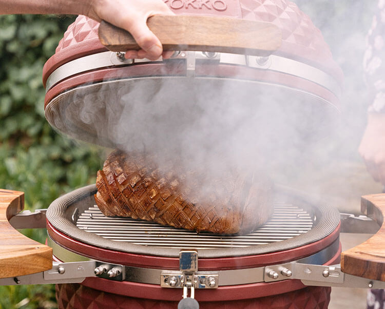 Kamado Kokko utilizzato per l’affumicatura a caldo, mostra la cottura degli alimenti con produzione di fumo per un aroma intenso.