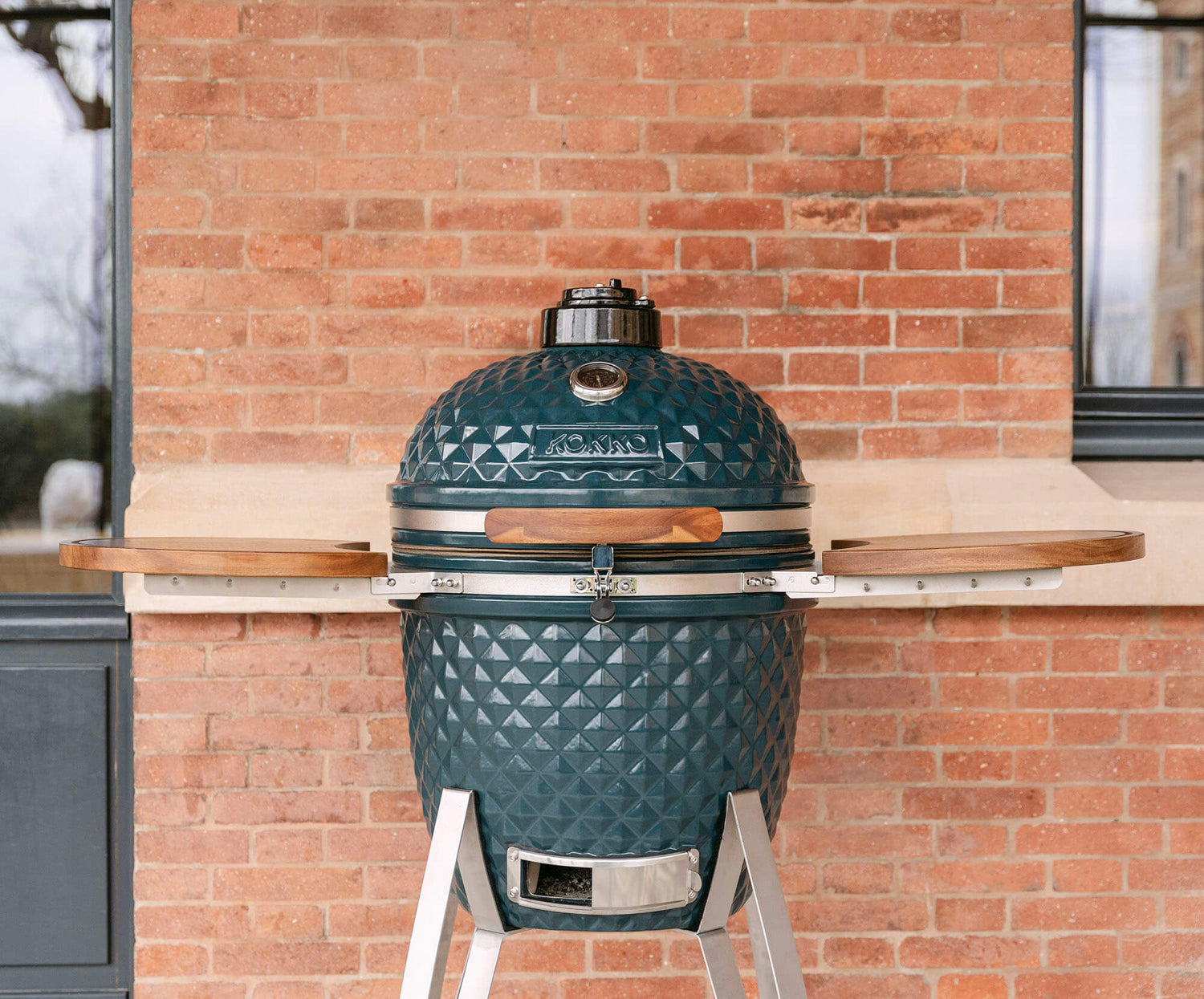 Kamado Kokko nuova edizione presentato sul suo carrello, valorizzando il design, la ceramica testurizzata e l’integrazione in uno spazio esterno.