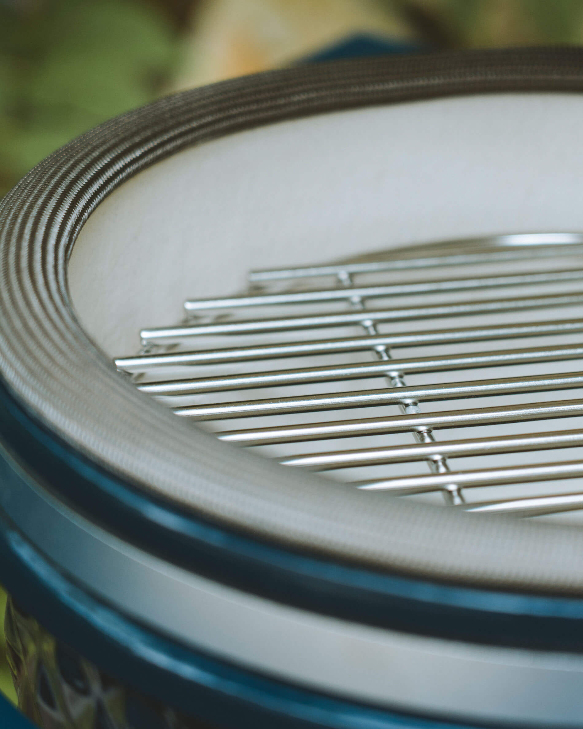 Primo piano sulla griglia di cottura in acciaio inox e sulla guarnizione del coperchio di un kamado Kokko color oceano.