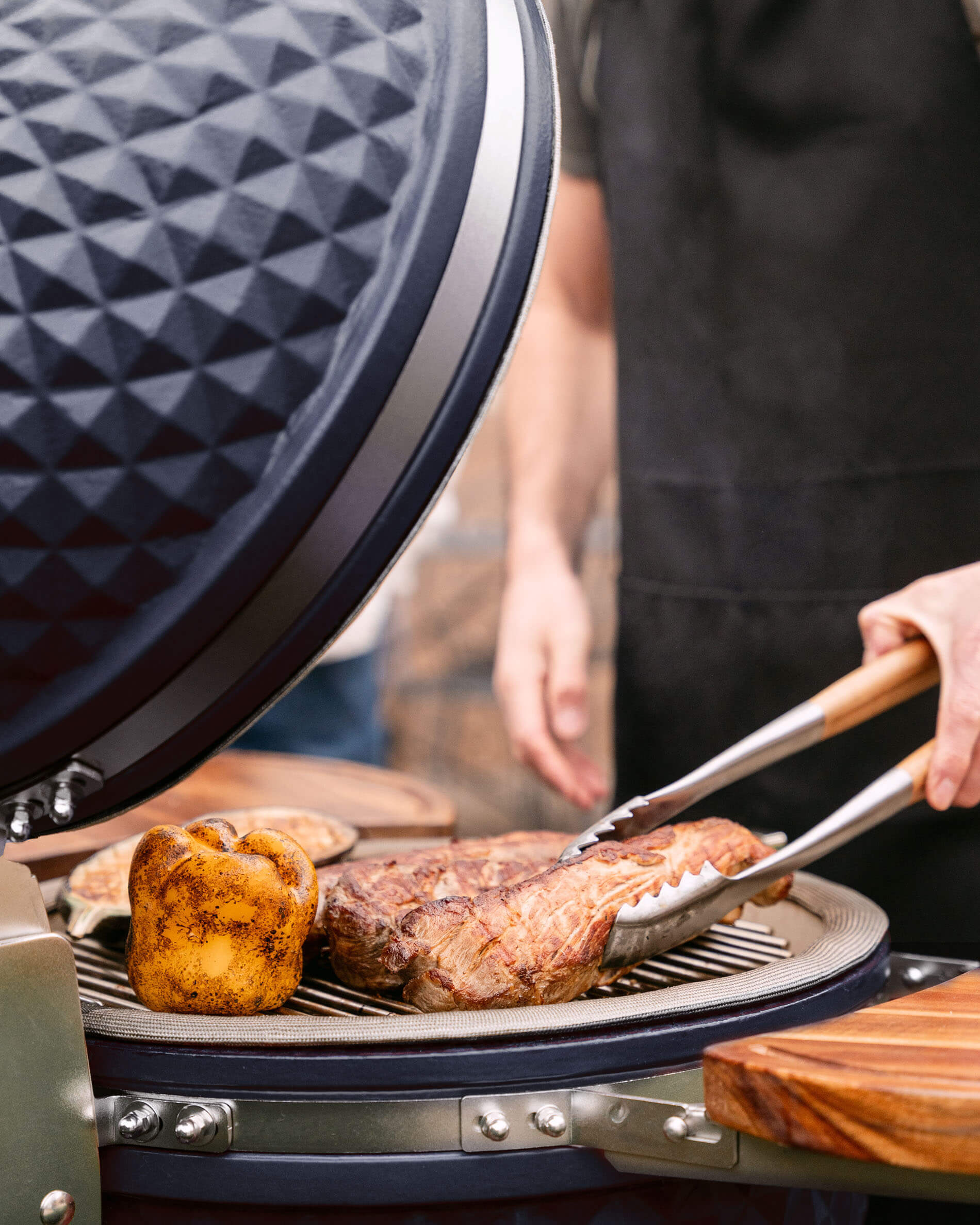 Kamado Kokko L 18 pollici blu navy durante una grigliata.