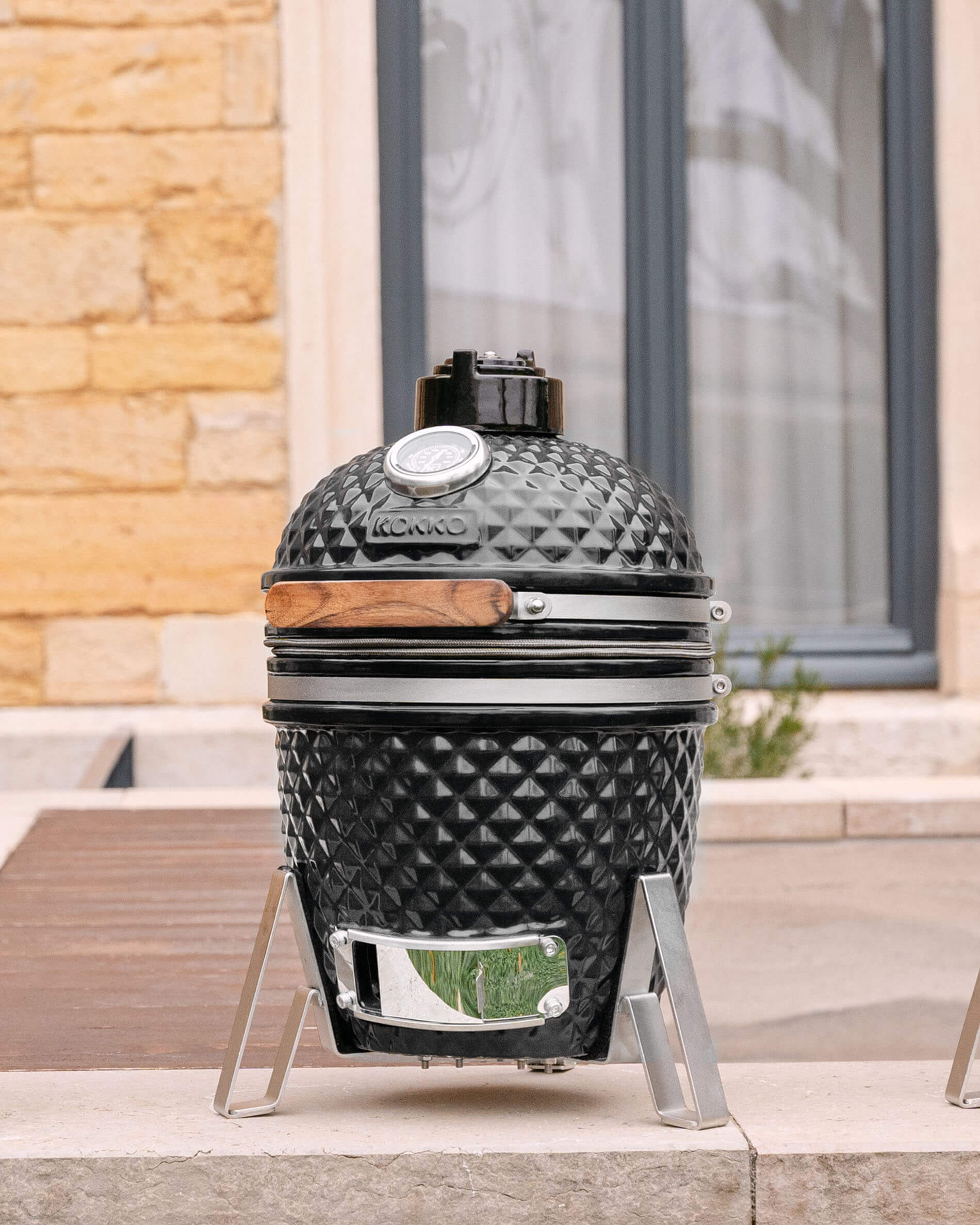 Kamado Little Kokko 13 in ceramica nero profondo sul suo supporto.
