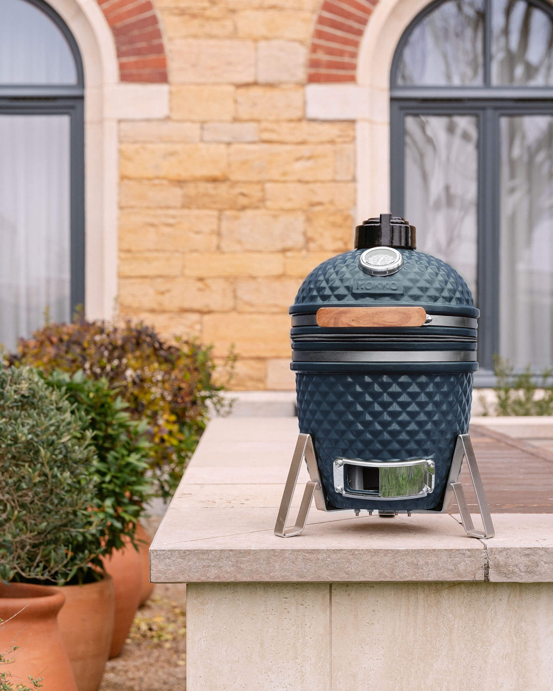 Kamado Little Kokko 13 in ceramica blu oceano, installato all’esterno.