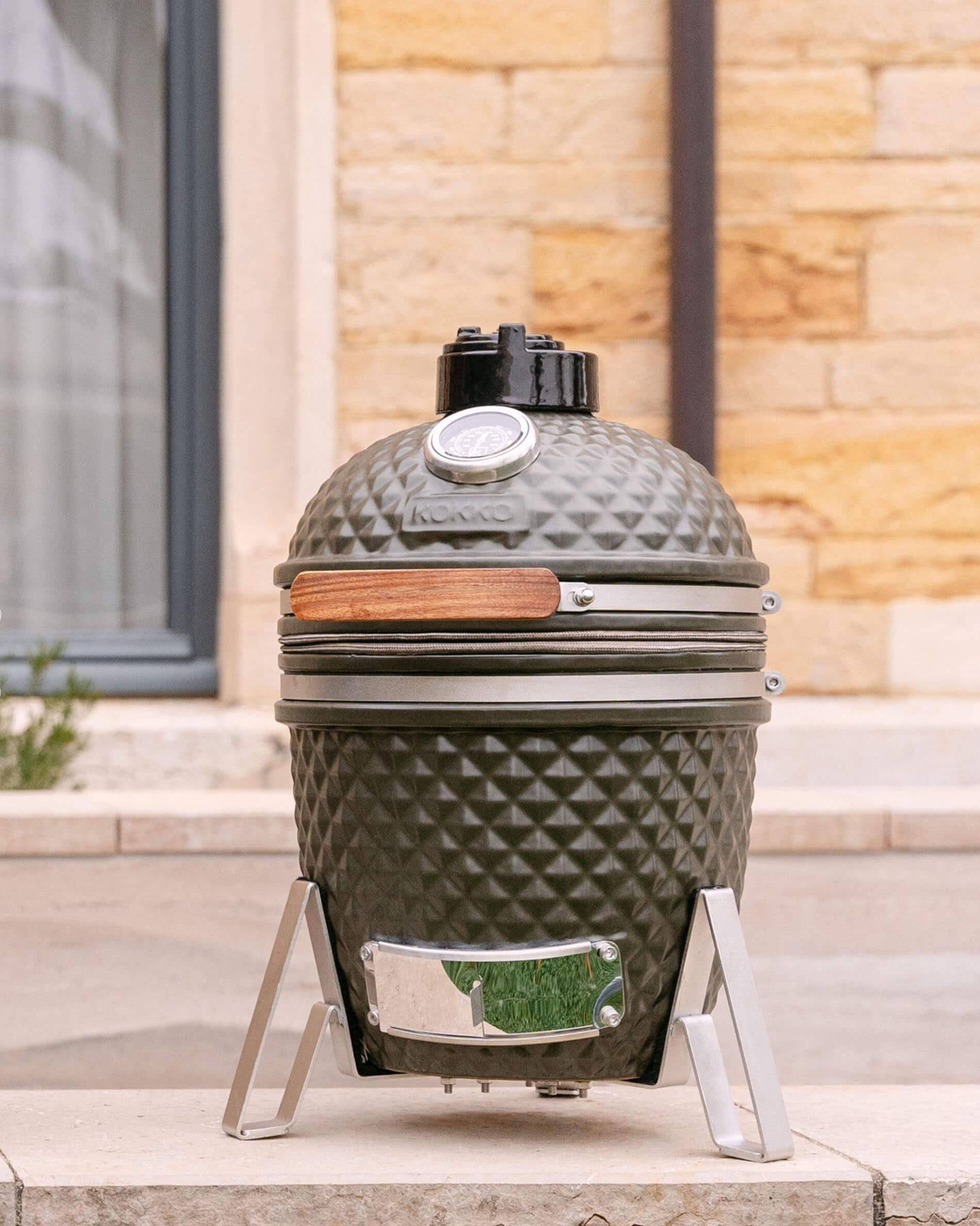 Kamado Little Kokko 13 in ceramica verde oliva sul suo supporto.