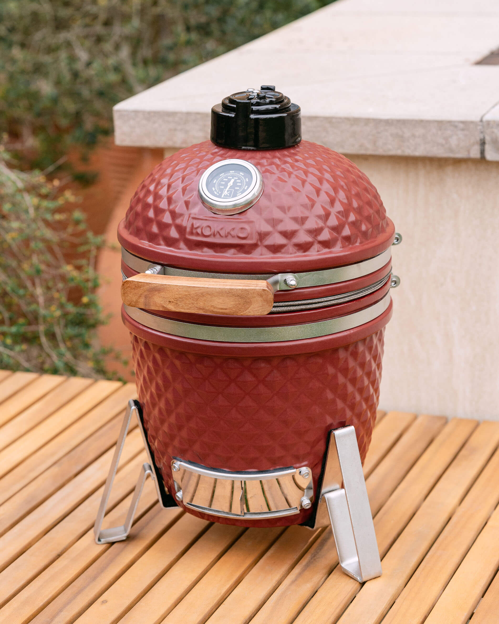 Kamado Little Kokko 13 rosso ossido posizionato su una terrazza.