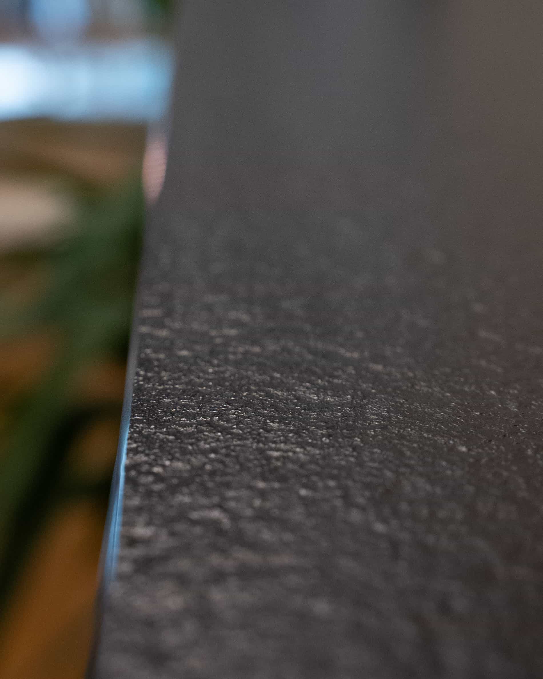 Dettaglio del piano di lavoro di una cucina su palafitte, che mostra il bordo, la texture opaca e la finitura del materiale.