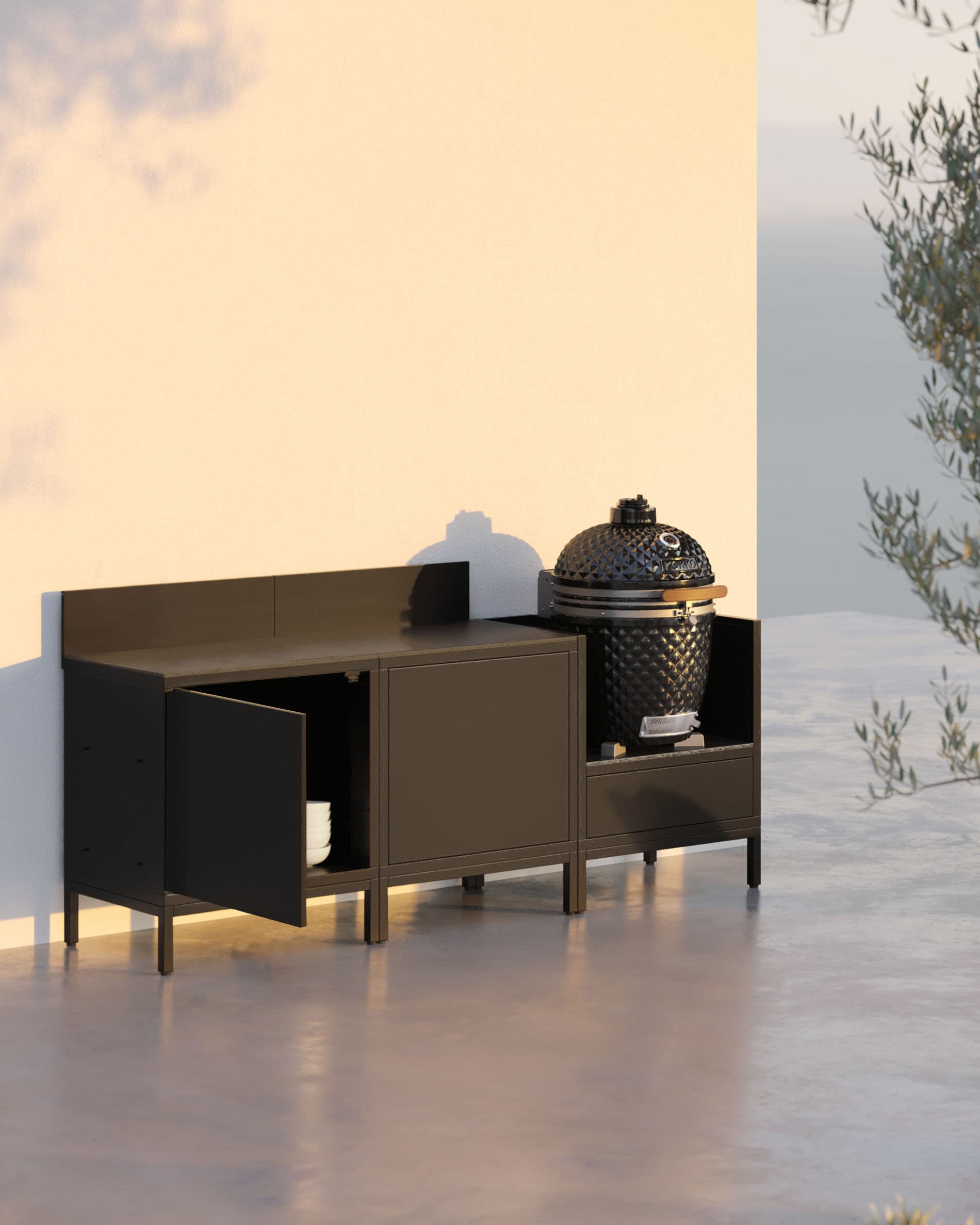 Cucina su palafitte 3 moduli con kamado, mobile nero e una porta portaoggetti aperta.