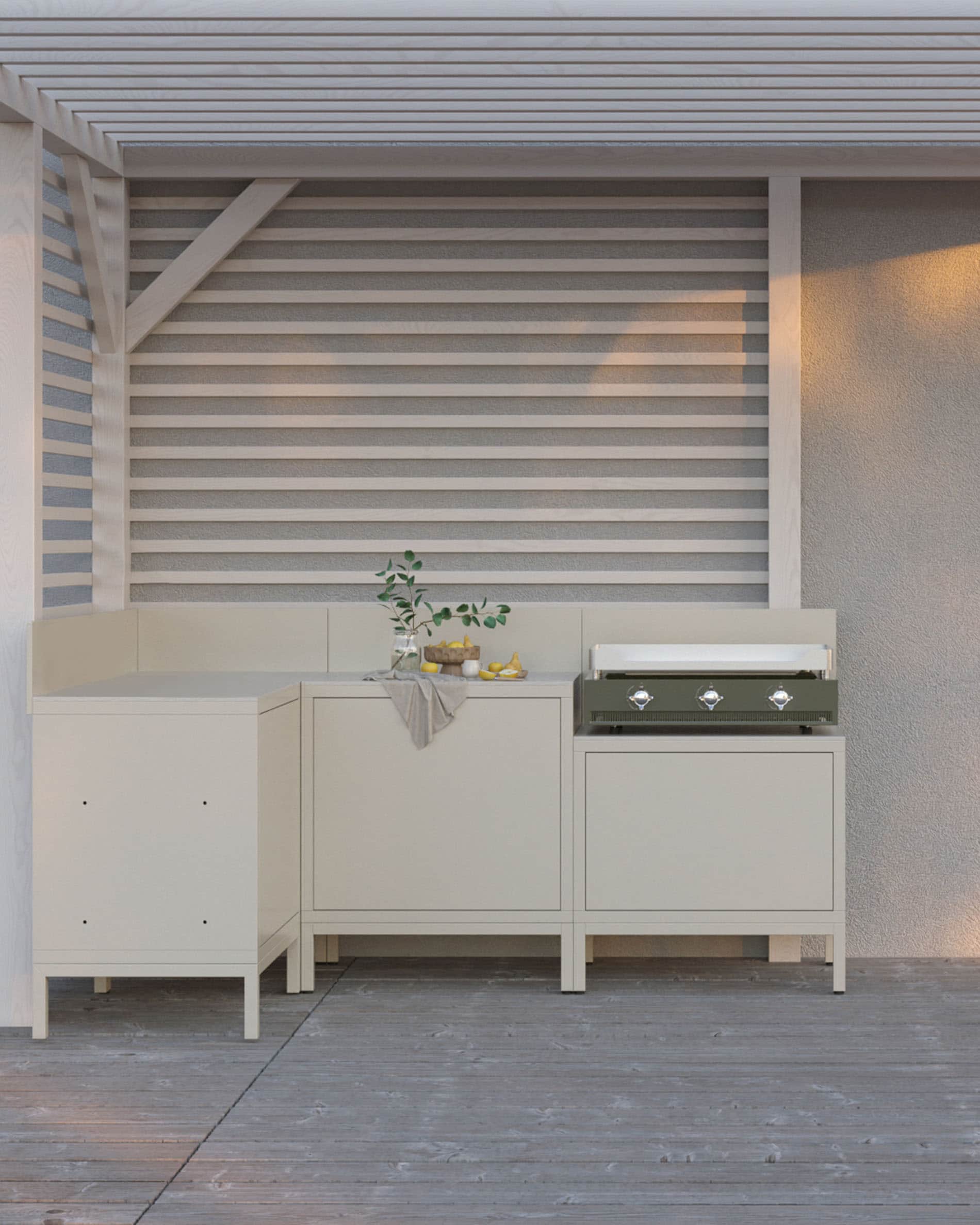 Cucina da esterno su palafitte con plancha integrata, mobili color crema, vani chiusi e piano di lavoro chiaro, installata sotto una pergola.