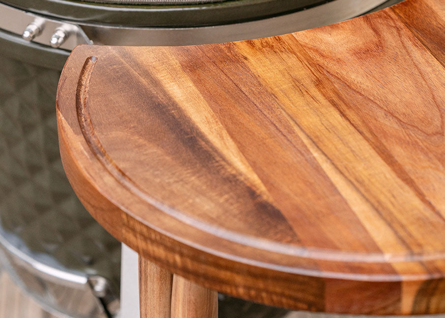 Ripiano laterale in legno di acacia per kamado Kokko, fissato alla struttura metallica per offrire una superficie di preparazione.